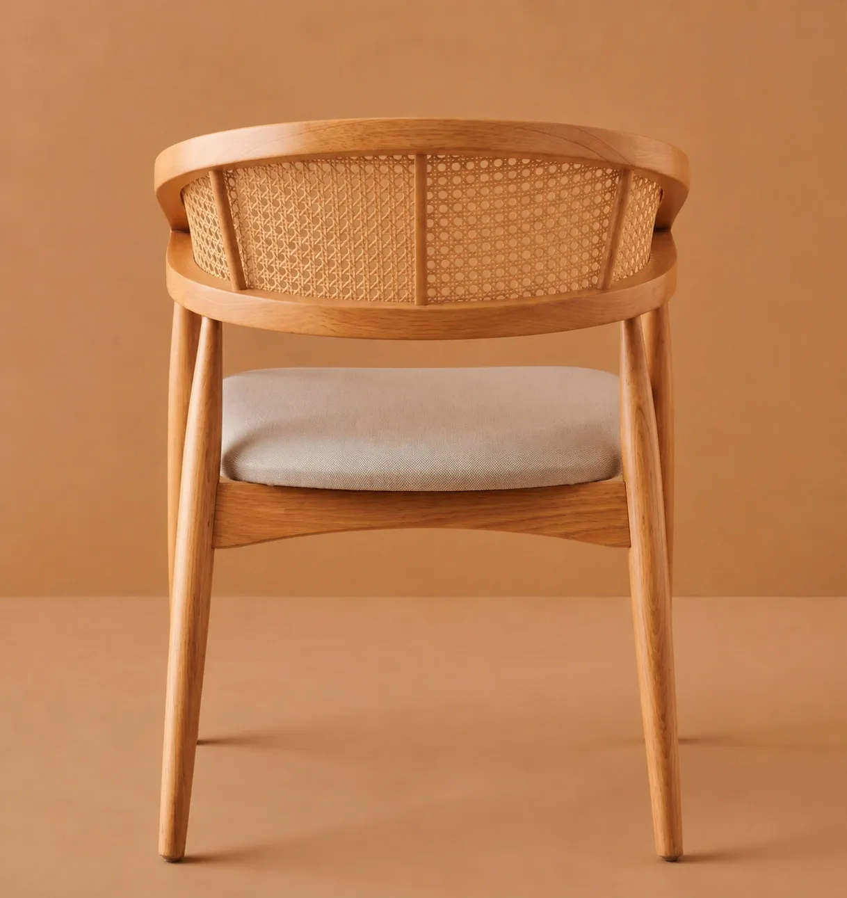 Wooden dining chair with a curved rattan cane backrest and cushioned seat